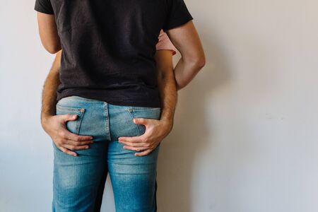 Stock photo of two caucasian homosexual men hugging each other. One of them is holding the others butt. They are unrecognizable.の写真素材