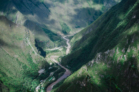 Stock photo of a bird eye view of a sinuous river in between the mountains.
