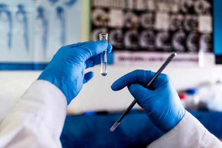 Stock photo of unrecognized scientist holding test tubes in the laboratory.