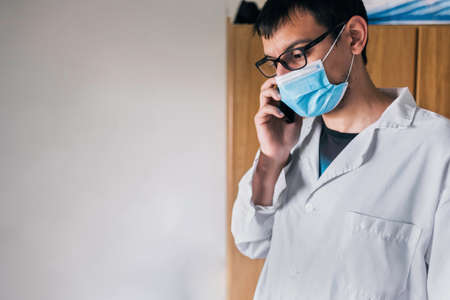 Stock photo of male scientist looking at his cellphone in his laboratory.の写真素材