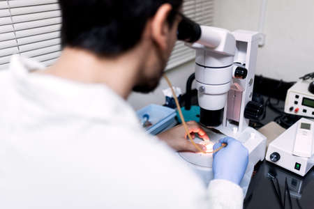Stock photo of male scientist using a microscopy in his lab.の写真素材