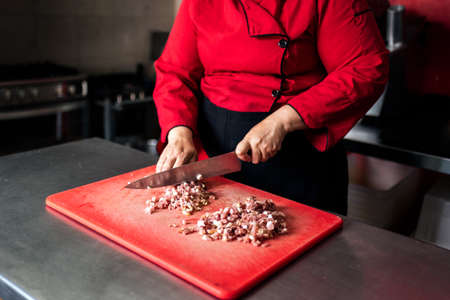 Stock photo of unrecognized chef working in the kitchen chopping meat.の写真素材