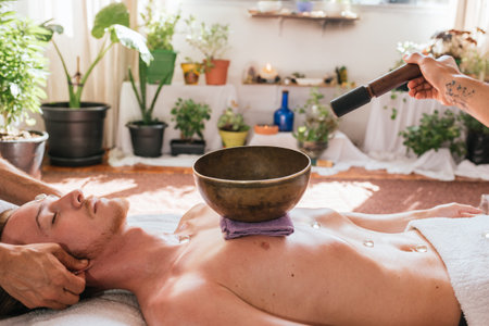 Stock photo of relaxed man lying in the floor and receiving body massage with natural plants.の写真素材