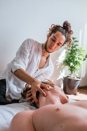 Stock photo of relaxed man enjoying neck massage while lying in a towel.の写真素材