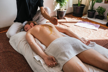 Stock photo of relaxed man enjoying back massage while lying in the floor.の写真素材