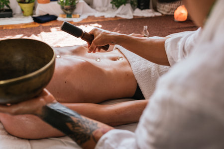 Stock photo of unrecognized man lying in the floor and receiving body massage with natural plants.の写真素材
