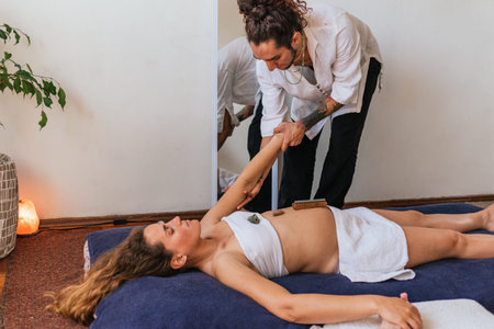 Pregnant woman lying on the floor and receiving massage with natural oils.の写真素材