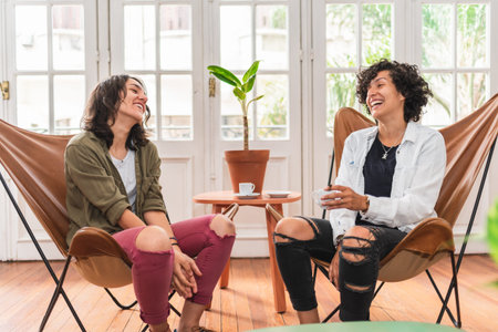 Stock photo of happy couple sitting in their apartment looking at each other and smiling.の写真素材