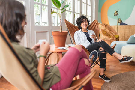 Stock photo of happy couple sitting in their apartment talking and smiling.の写真素材