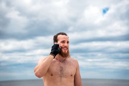 Happy man using his phone outdoors after working out.の写真素材