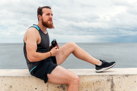 Focused bearded man using jumping rope outdoors and looking at front.