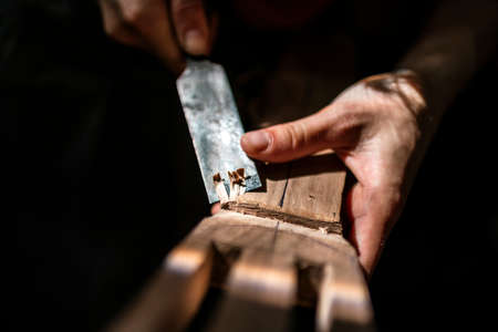 Unrecognized luthier creating a guitar and using tools in a traditional workshop.の写真素材