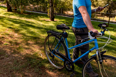 Unrecognizable man walking in the park with his bicycleの写真素材
