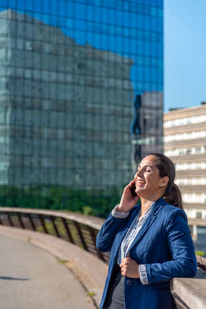 Caucasian business woman with mobile phone in the cityの写真素材
