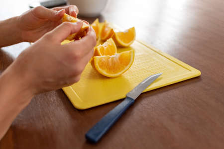 Unrecognizable white woman cutting orange for a healthy breakfast.の写真素材