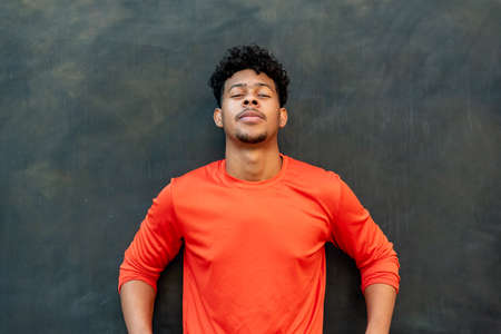 Portrait of young latin man against a wallの写真素材