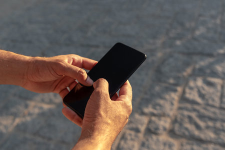 Unrecognizable white man grabbing a mobile phone.