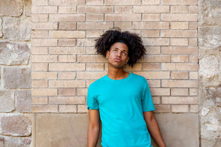 Afro latin male teenager against a wall, looking up.の写真素材