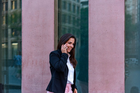 Caucasian businesswoman talking by mobile phone in the cityの写真素材