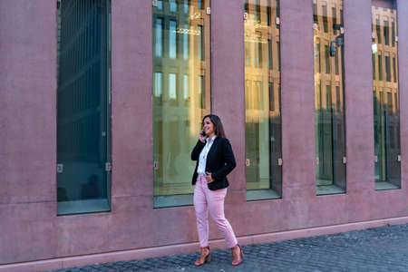 Caucasian businesswoman talking by mobile phone in the cityの写真素材