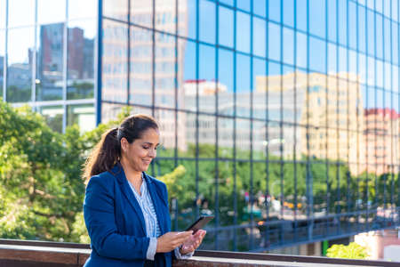Caucasian mid adult businesswoman with mobile phone in the cityの写真素材