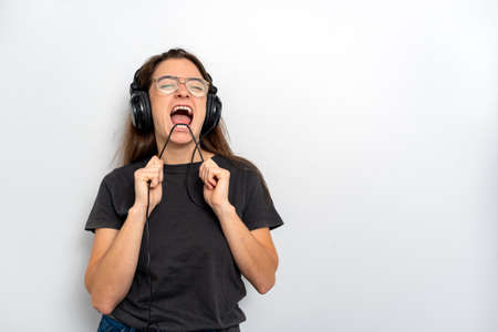 Young latin woman with headphones against white backgroundの写真素材