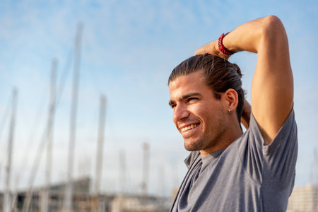 Young latin man stretching after doing exercise outdoorsの写真素材