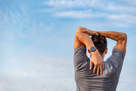 Young latin man stretching after doing exercise outdoorsの写真素材