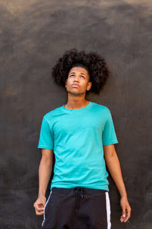Portrait of young afro latin man against a black wallの写真素材