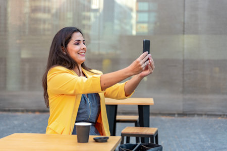 Caucasian mid adult businesswoman videocalling with mobile phone