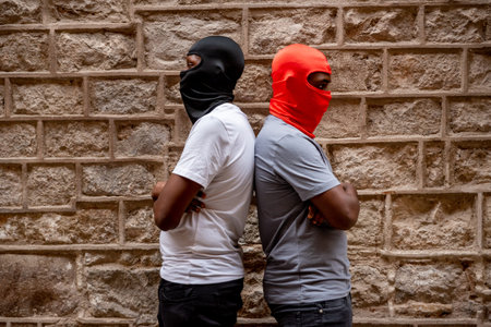 Two afro young men in ski masks in alleyway