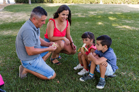 Family with children eating healthy outdoors