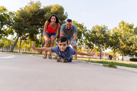 Kid playing with his parents while roller skating outdoors in the park.の写真素材