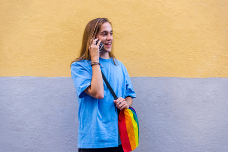 Man talking on the phone while wearing a belt bag with the lgbt rainbow flag.の写真素材