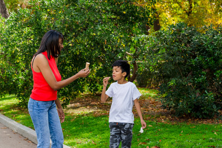 Mother and son enjoying eating ice-cream together outdoors in a park.の写真素材