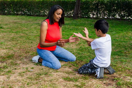 Happy mother and son enjoying together outdoors in a park.の写真素材