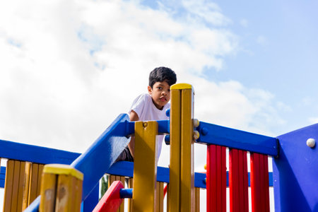 Young boy enjoying playing at the playground in the park.の写真素材
