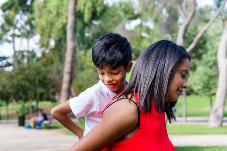 Happy mother and son enjoying together outdoors in a park.