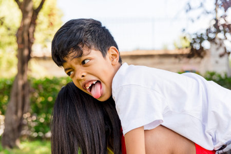 Happy mother and son enjoying together outdoors in a park.の写真素材