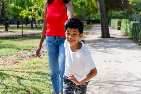Happy mother and son enjoying together outdoors in a park.の写真素材