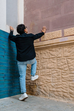 Unrecognizable person hanging on the walls outdoors.