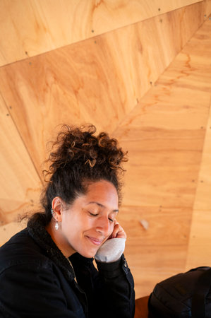 Happy Latin woman smiling while sitting indoors.