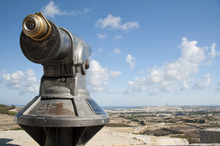 Telescope looking over the fields and houses and the sea coast on the island of Gozoの写真素材