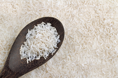  wooden spoon with basmati rice on background of riceの写真素材