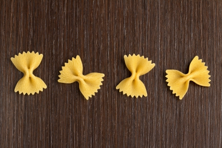 four bow tie pasta on wooden backgroundの写真素材