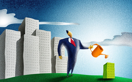 businessman watering a little green building in a cityscapeの写真素材