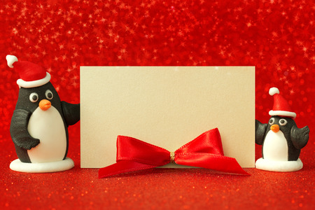 two small penguins holding a blank cardの写真素材