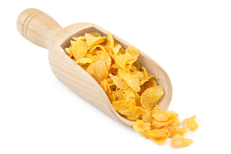 corn flakes in a wooden scoop isolated on white backgroundの写真素材
