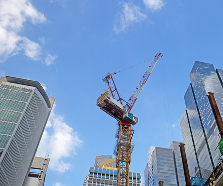 crane among skyscrapers in downtown under a blue skyの写真素材