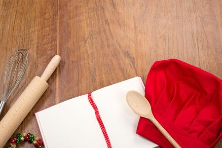 open cookbook chef39s hat and kitchen tools on wood table